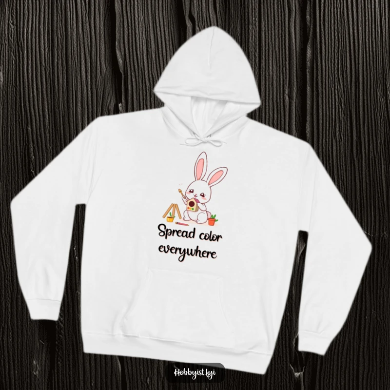 Funny Hoodie designed with a cute kawaii bunny painting a small, colorful birdhouse with great enthusiasm, perfect for cozy creativity.