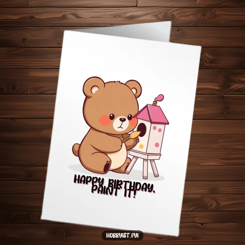 Funny free printable birthday card showing a cute bear character happily painting a vibrant birdhouse with a small, focused brush.