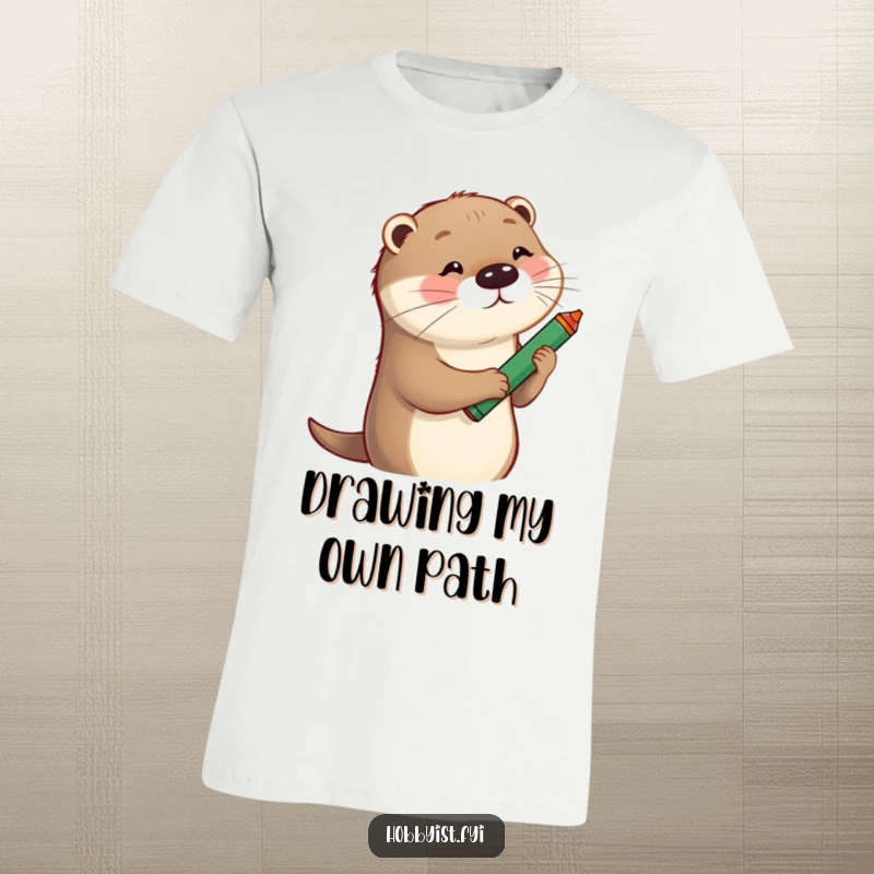 Funny T-Shirt depicting a playful otter enthusiastically sketching a whimsical portrait using a comically large crayon.